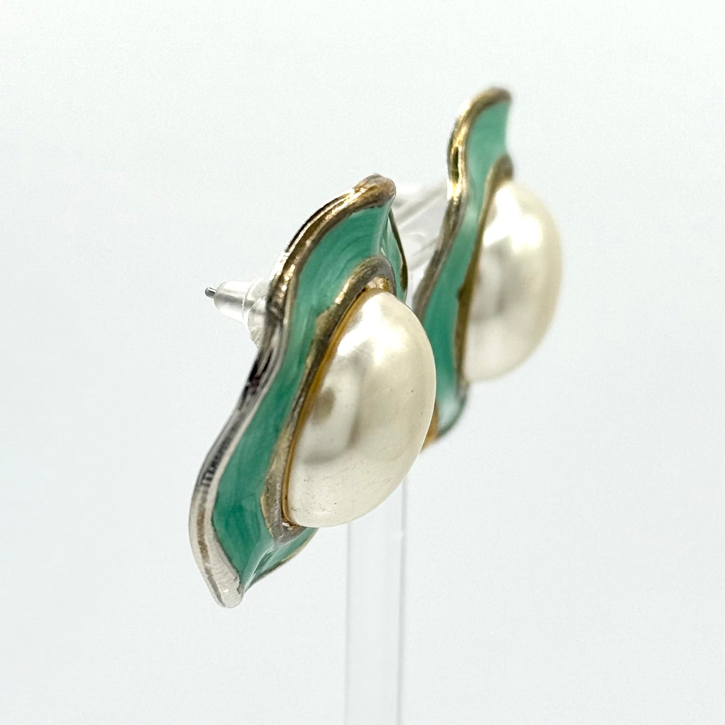 Pair of earrings with green and gold design on a white background