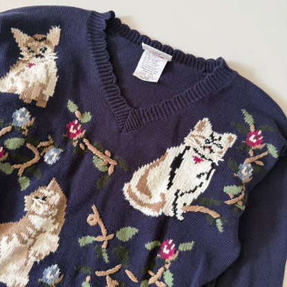 Navy blue sweater with cat and floral patterns on a white background