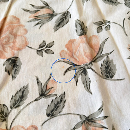 Floral patterned fabric with a blue circle highlighting an imperfection.