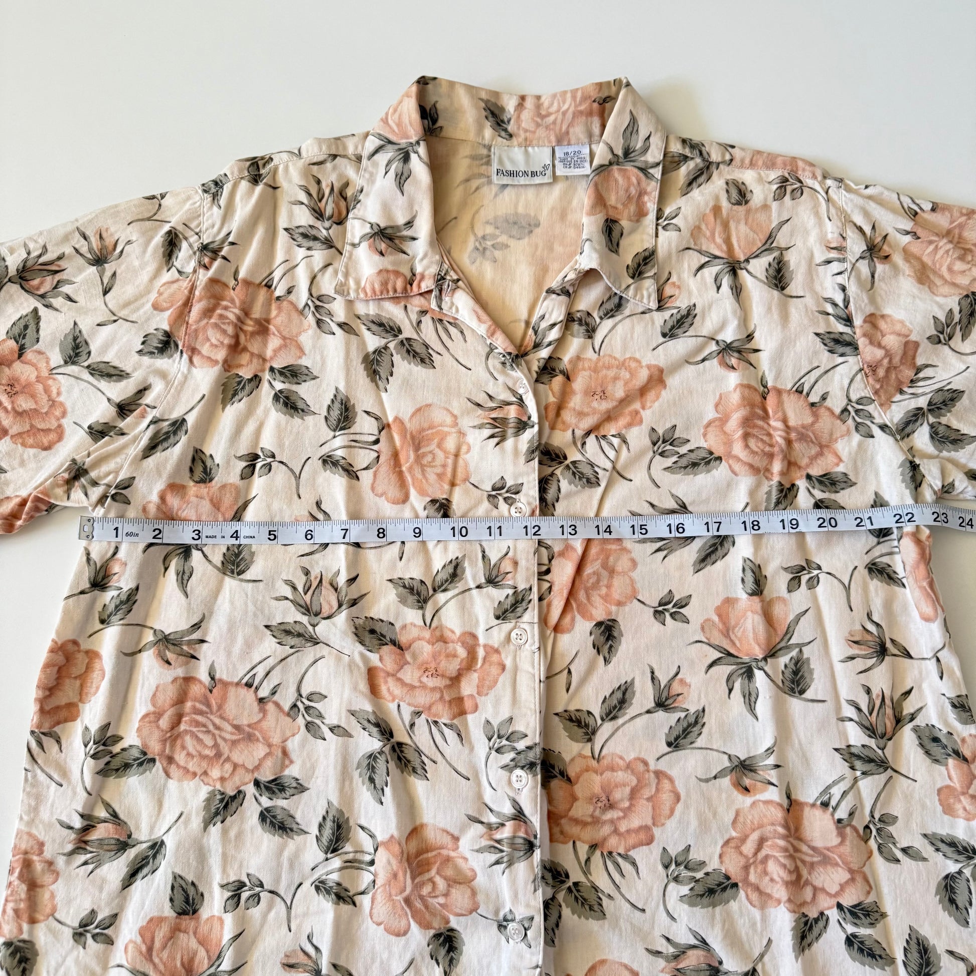 Floral patterned shirt with a measuring tape laid across it on a white background
