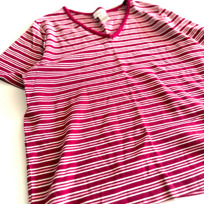 White, pink, and red striped t-shirt with a v-neck collar on a white backdrop. 
