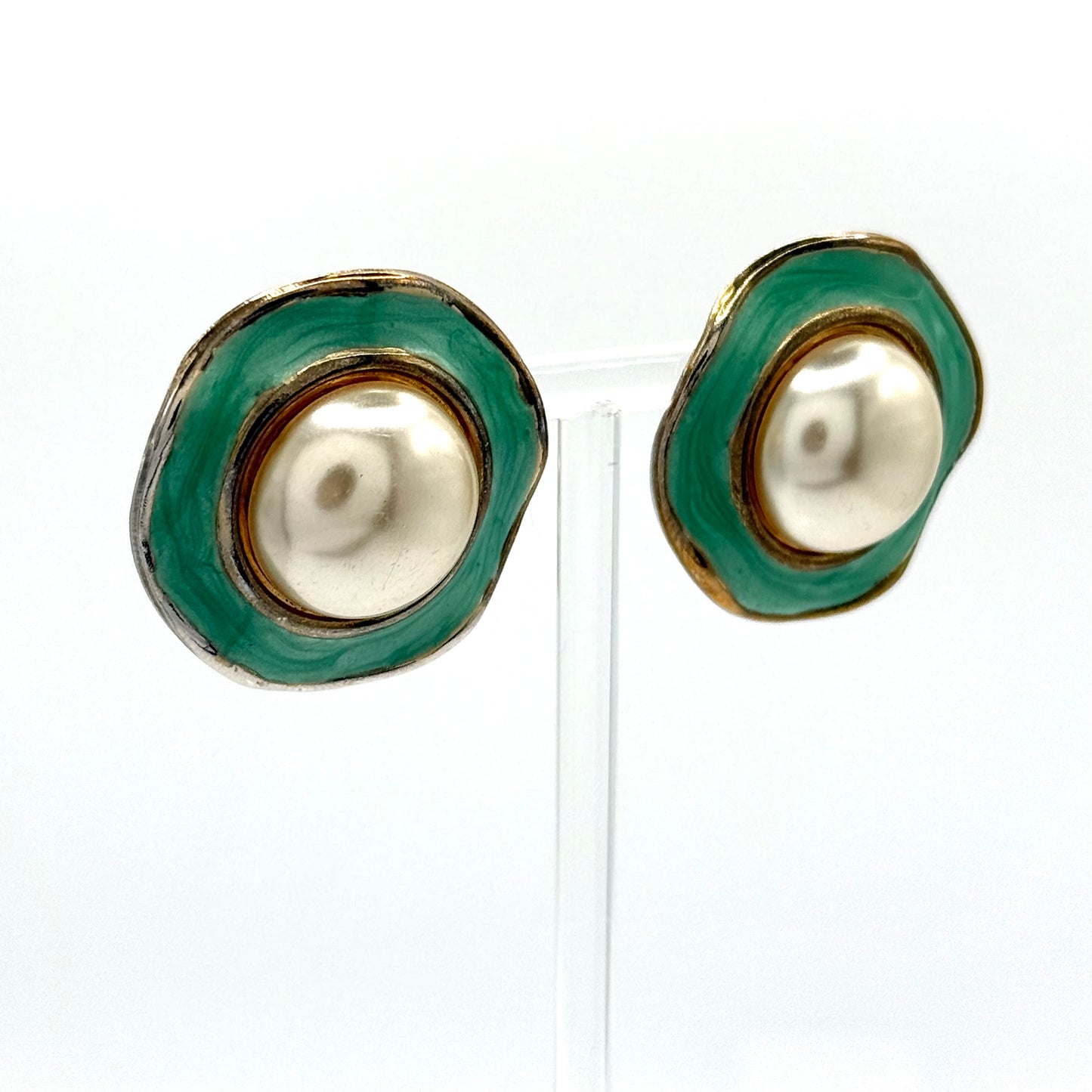 Pair of earrings with green and gold circular design on a white background