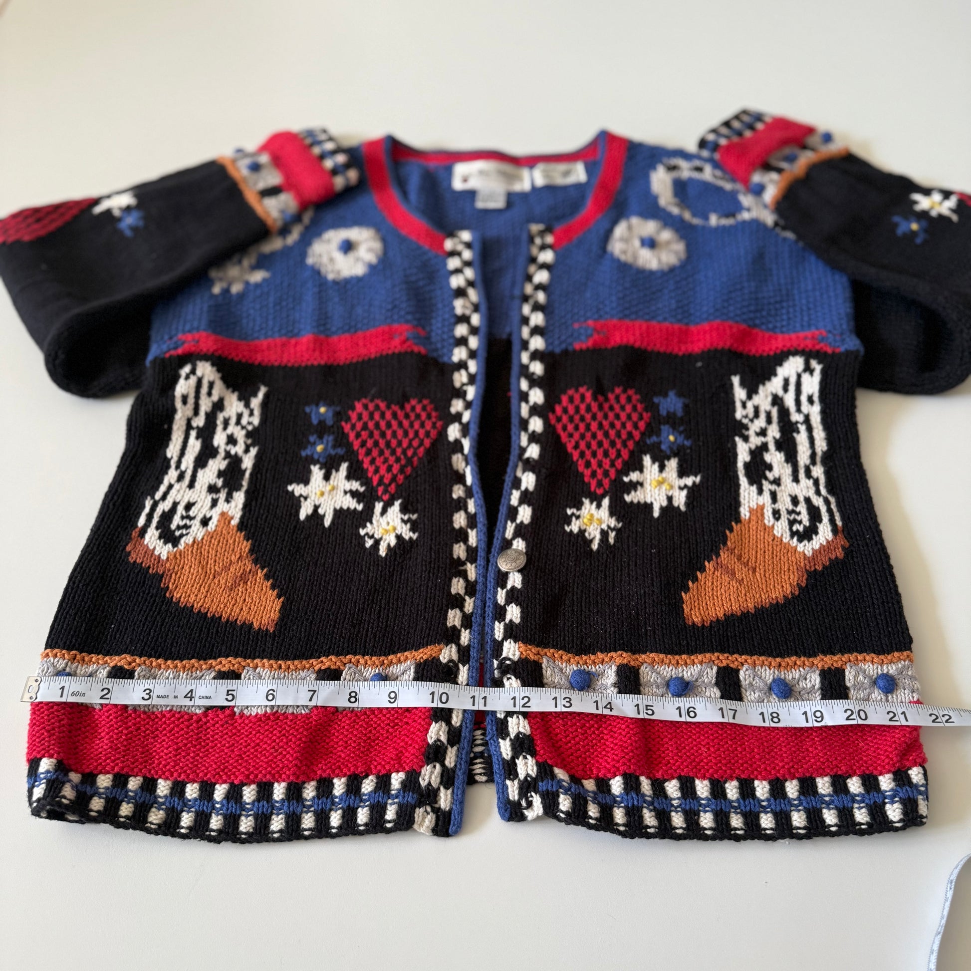 Colorful children's sweater with patterned design on a white background