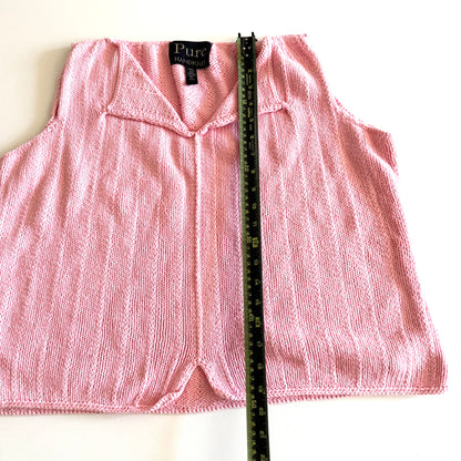 Light pink knit style tank top, with folded out collar opening on a white backdrop - with a measuring tape laid on top. 