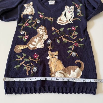 Navy blue sweater with cat pattern and measuring tape for size reference